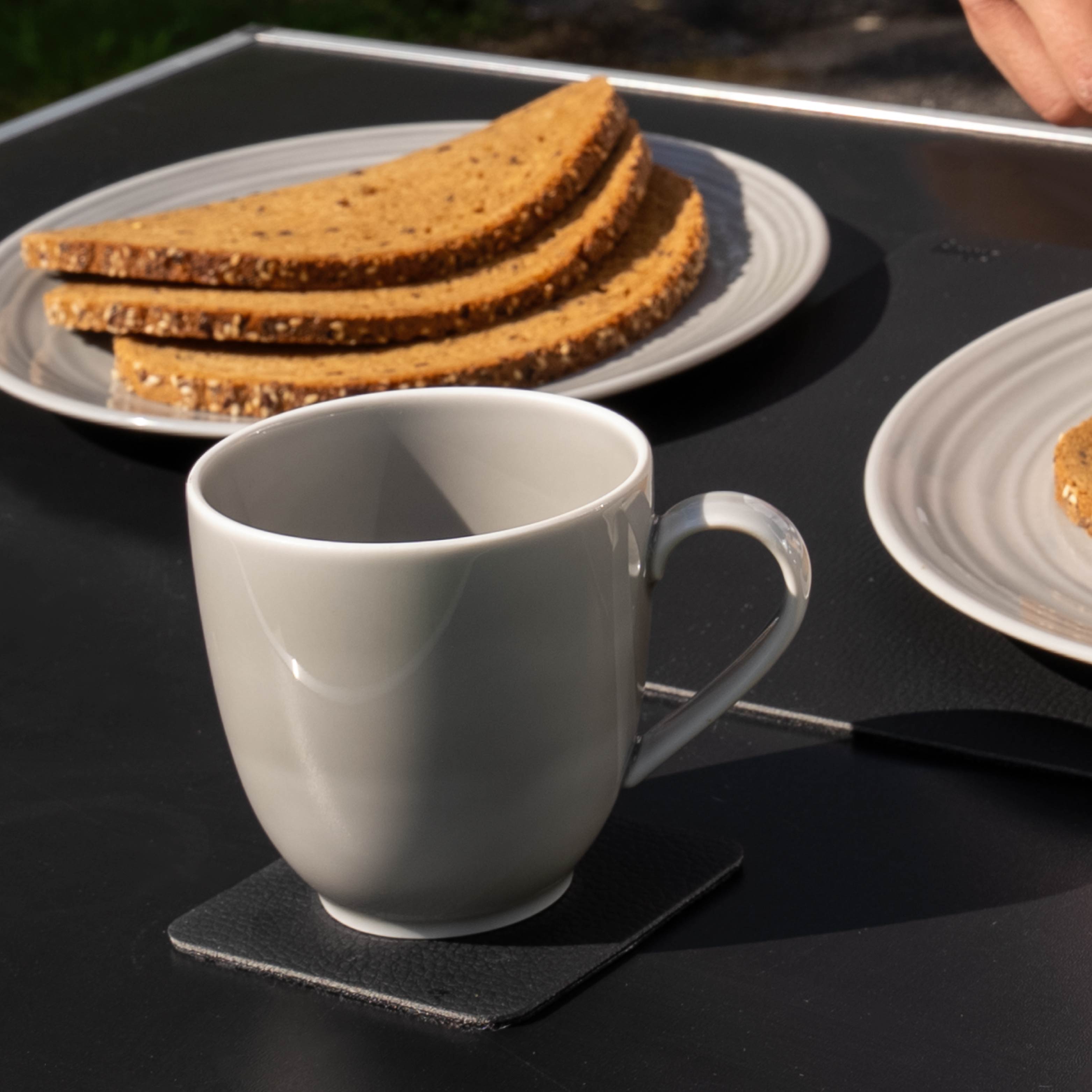 Magnet-Porzellan-Tasse ash auf Campingtisch