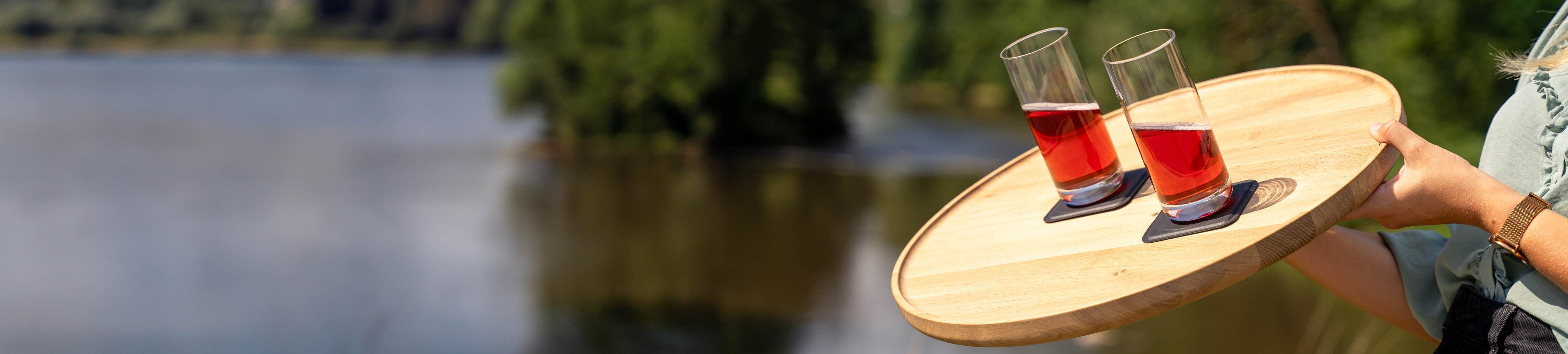 Magnet-Kristallgläser Longdrink slim auf pads abgestellt, die auf einem Holztablett platziert sind in Schräglage