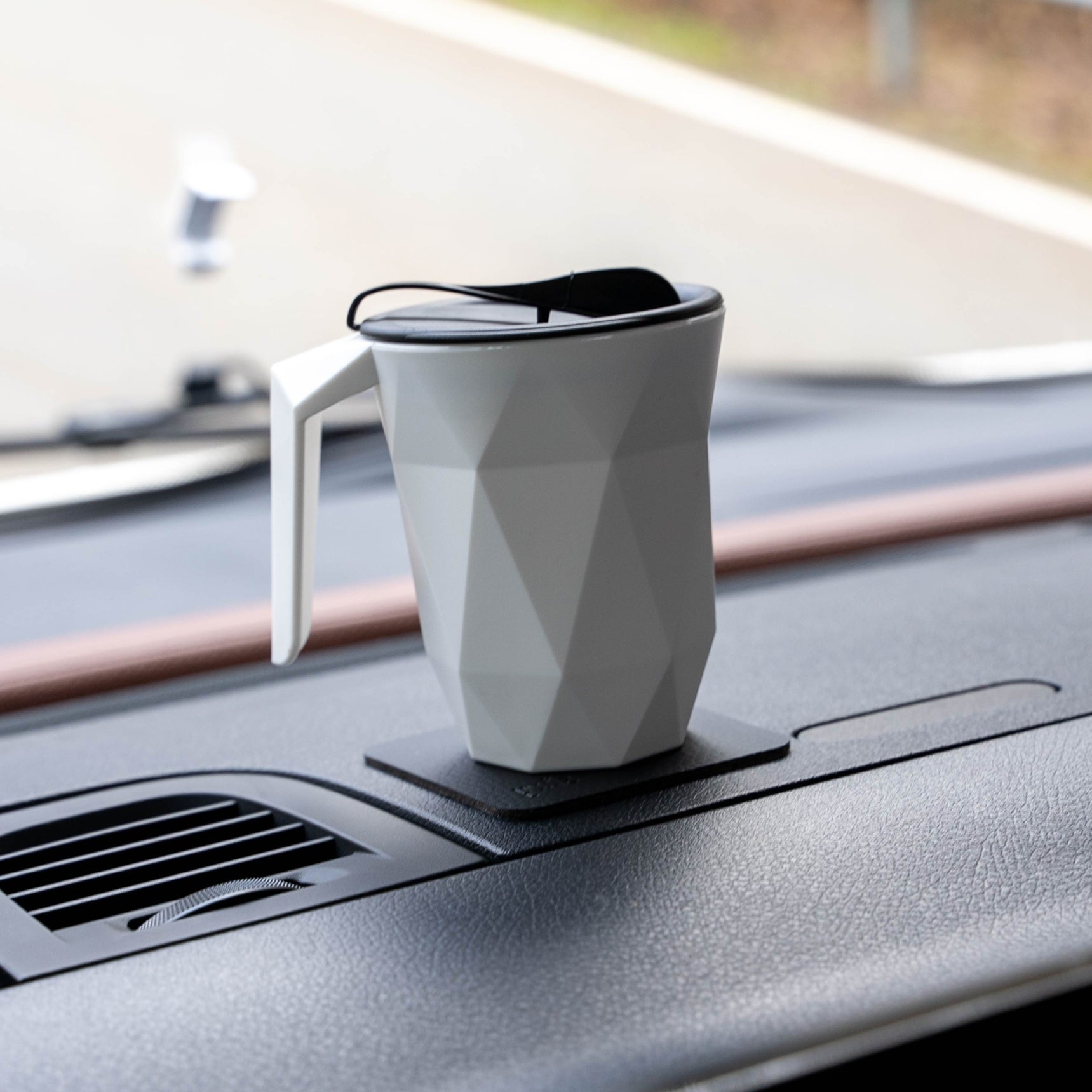 Magnet-Kunststofftasse TO-GO auf schwarzem quadratischen Pad in Auto