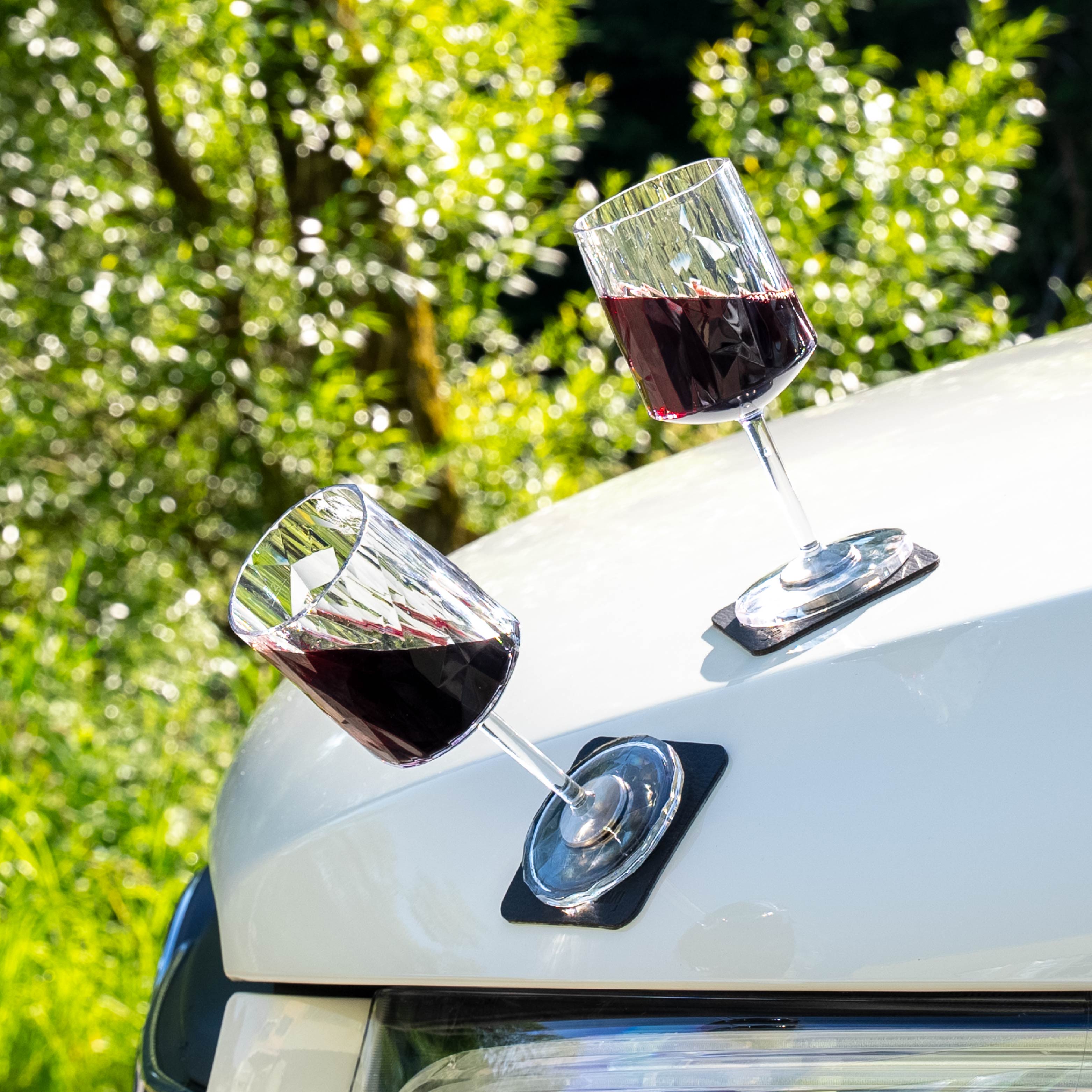 Magnet-Kunststoffgläser Wein auf metallischer Motorhaube abgestellt