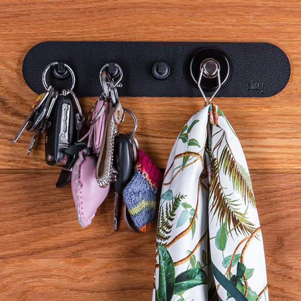 schwarze Metall-Leiste mit Pins und Haken und aufgehängten Schlüsseln