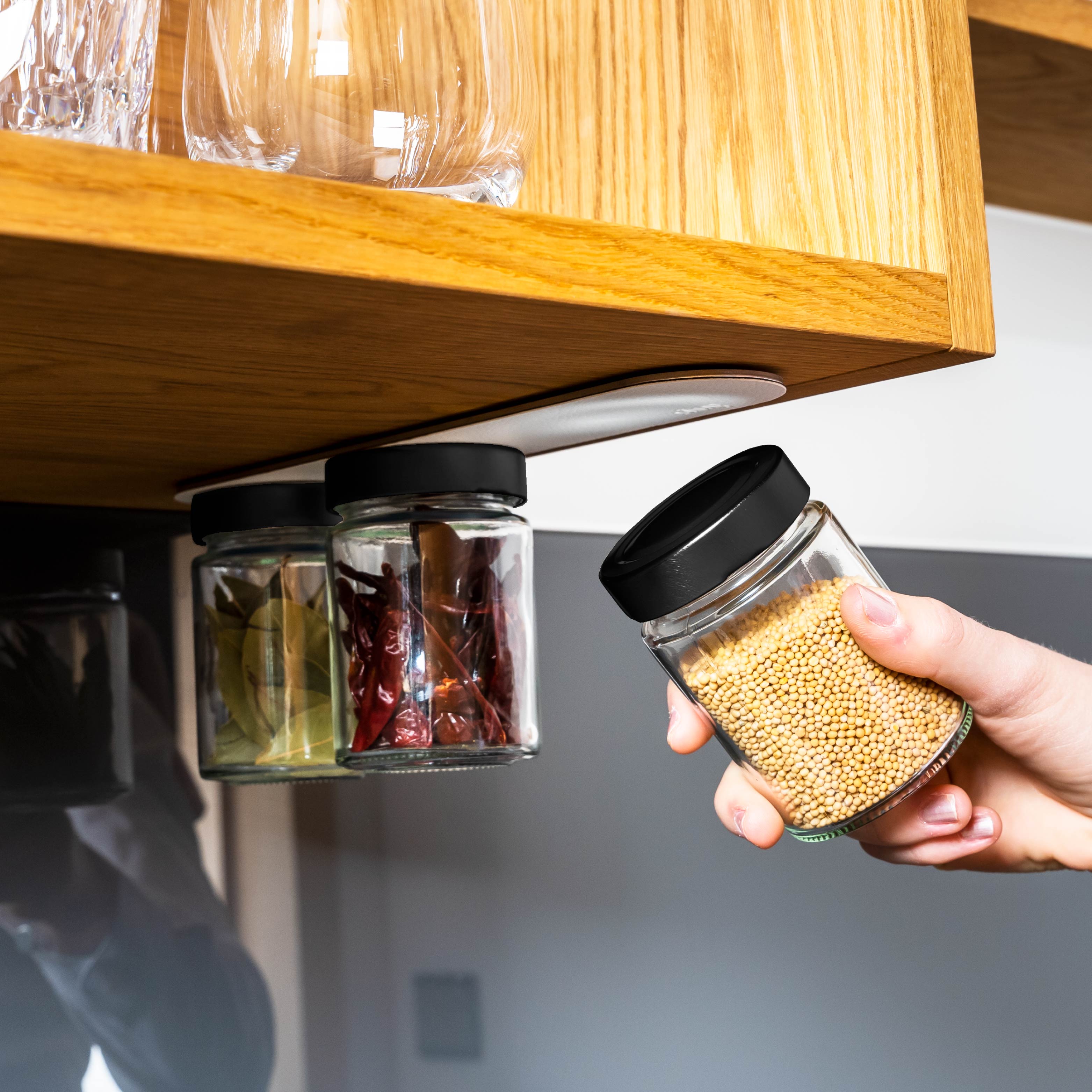 Magnet-Feinkostgläser an Metall-Leiste in Küchenumgebung montiert