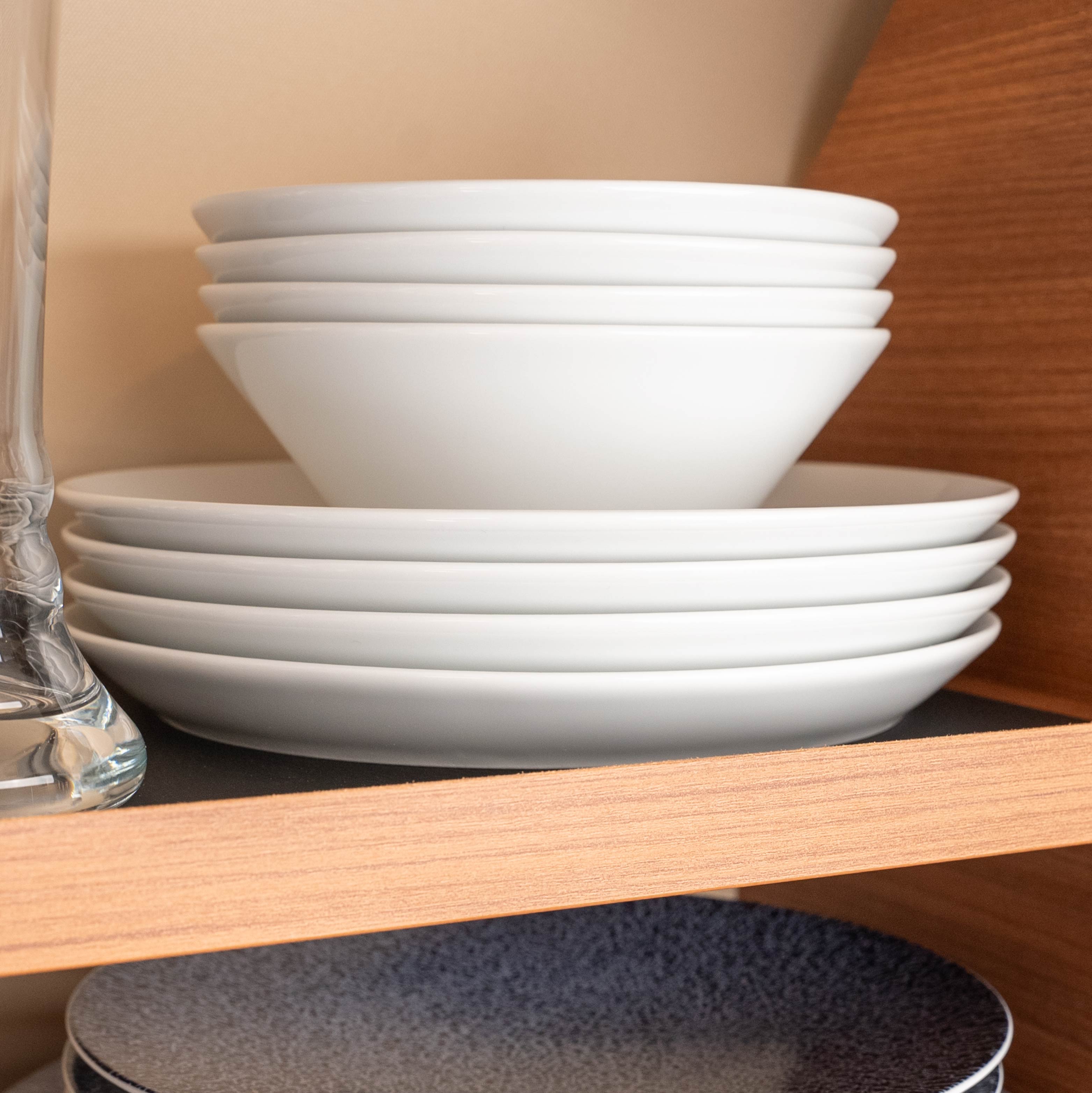 Magnet-Porzellan-Bowls und Magnet-Porzellanteller aufeinander gestapelt in Regal 