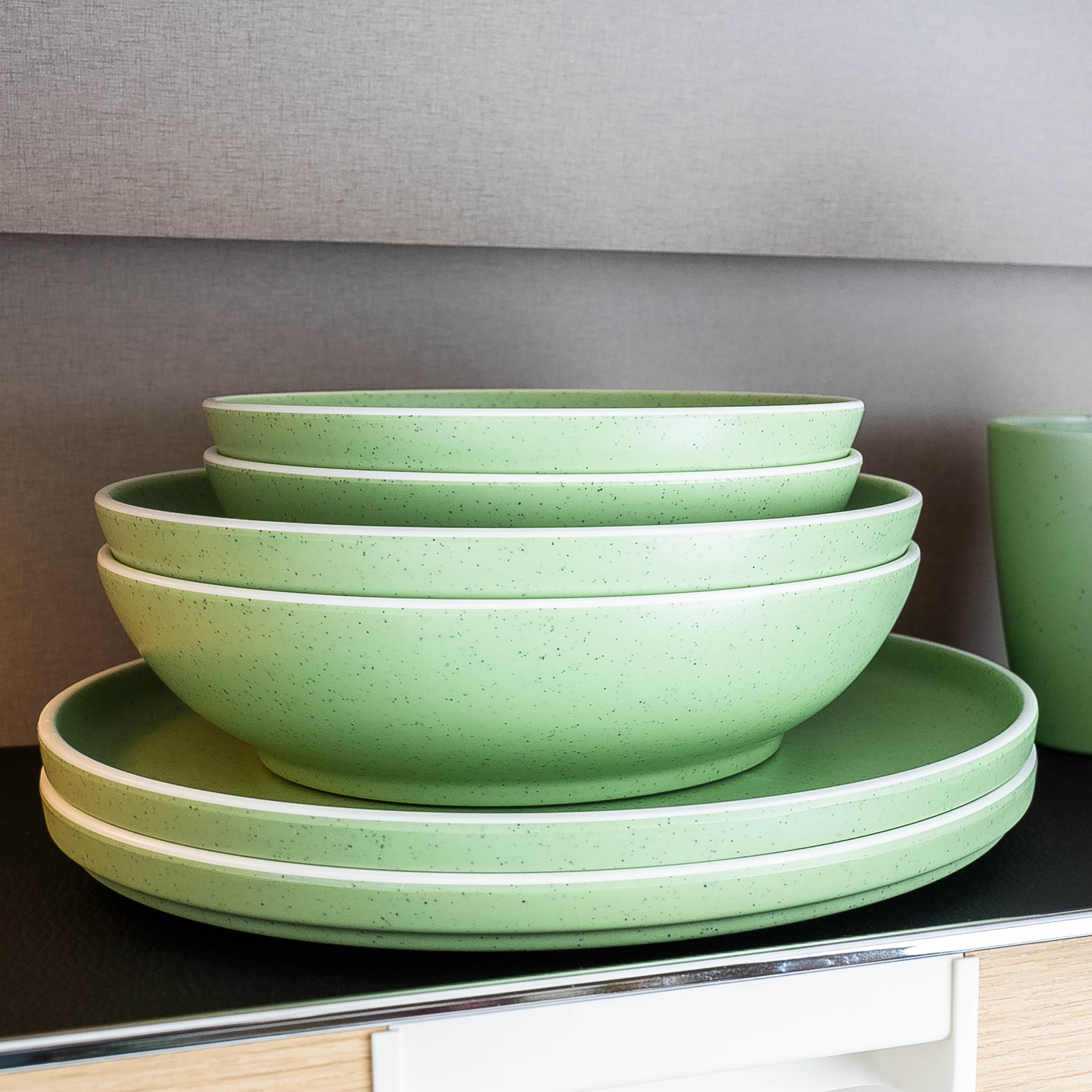 Platzsparend gestapeltes Geschirr Brunner im Schrank auf Matte