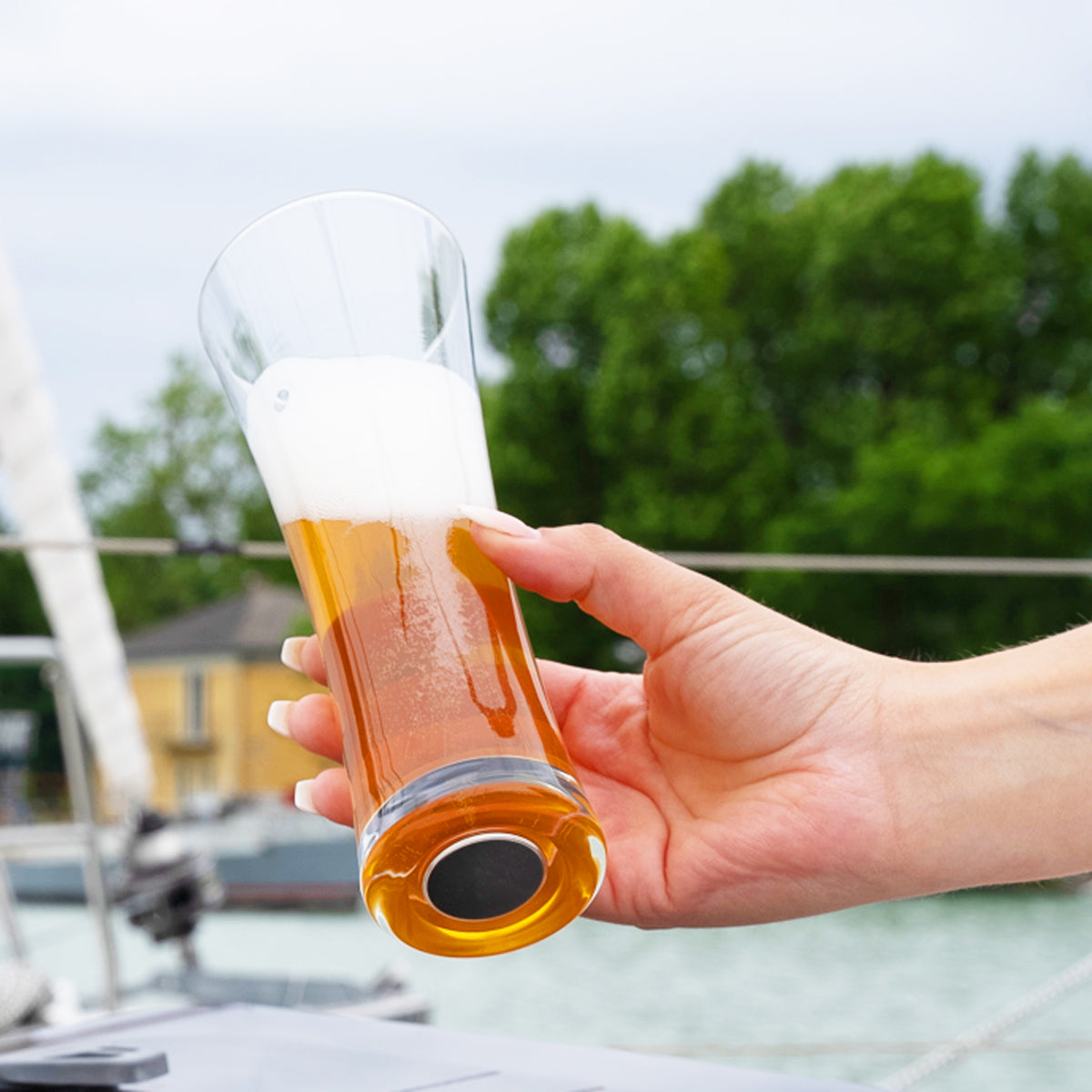 Magnet-Kristallglas Bier gefüllt mit Bier in die Luft gehalten 