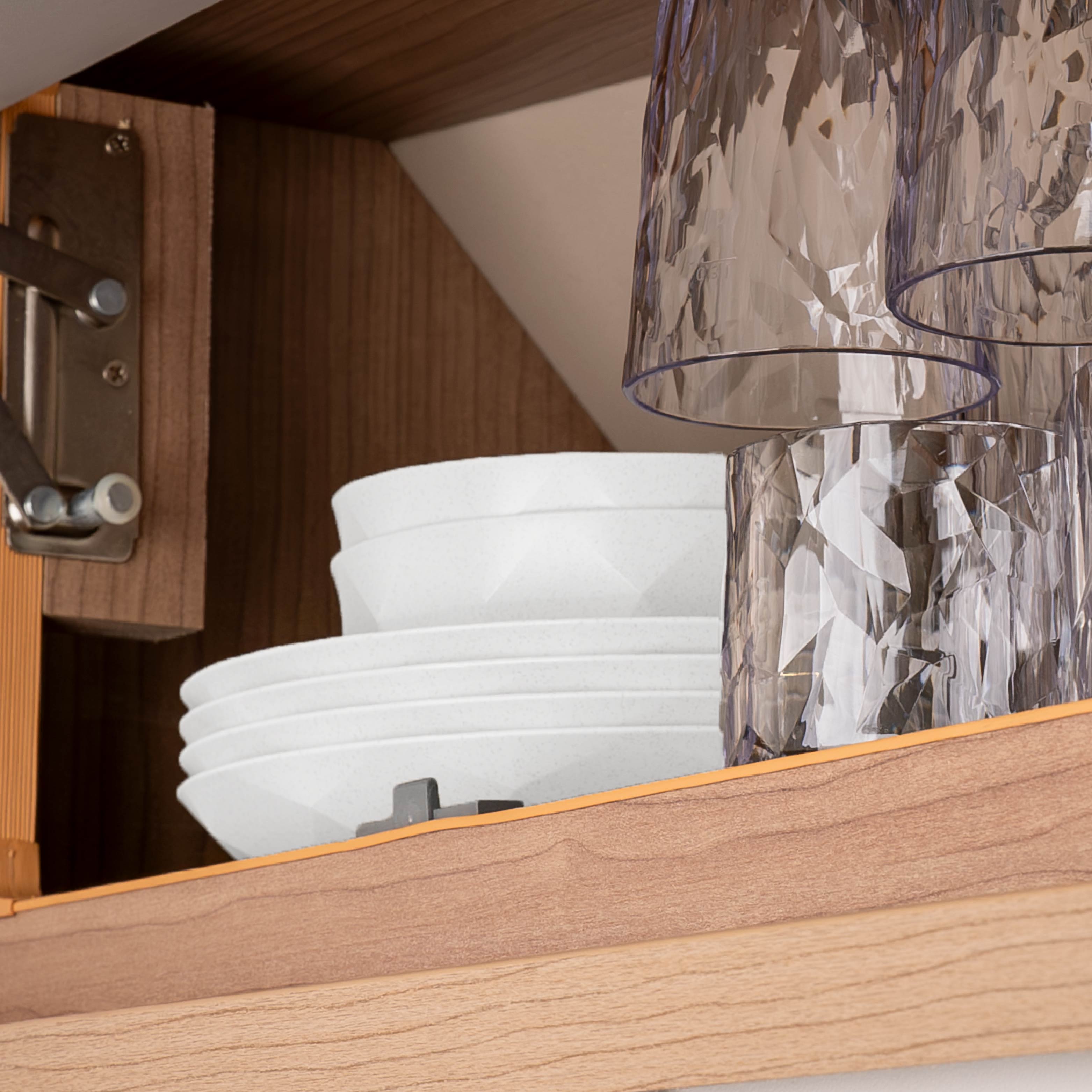 An der Metall-Leiste kopfüber hängende Kunststoffgläser mit Magnet in einem Schrank eines Campers