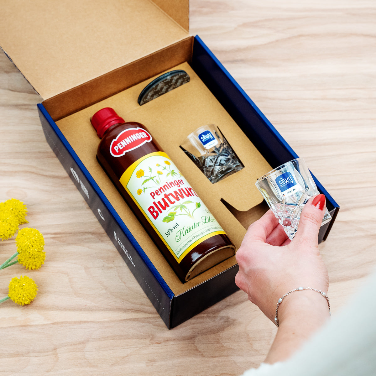 Geschenkbox Penninger Mountain Climber - Blaue Verpackung mit zwei Magnet-Kristallgläsern Shot, einer Flasche Penninger Blutwurz und runden Metall-Nano-Gel-Pads in schwarz
