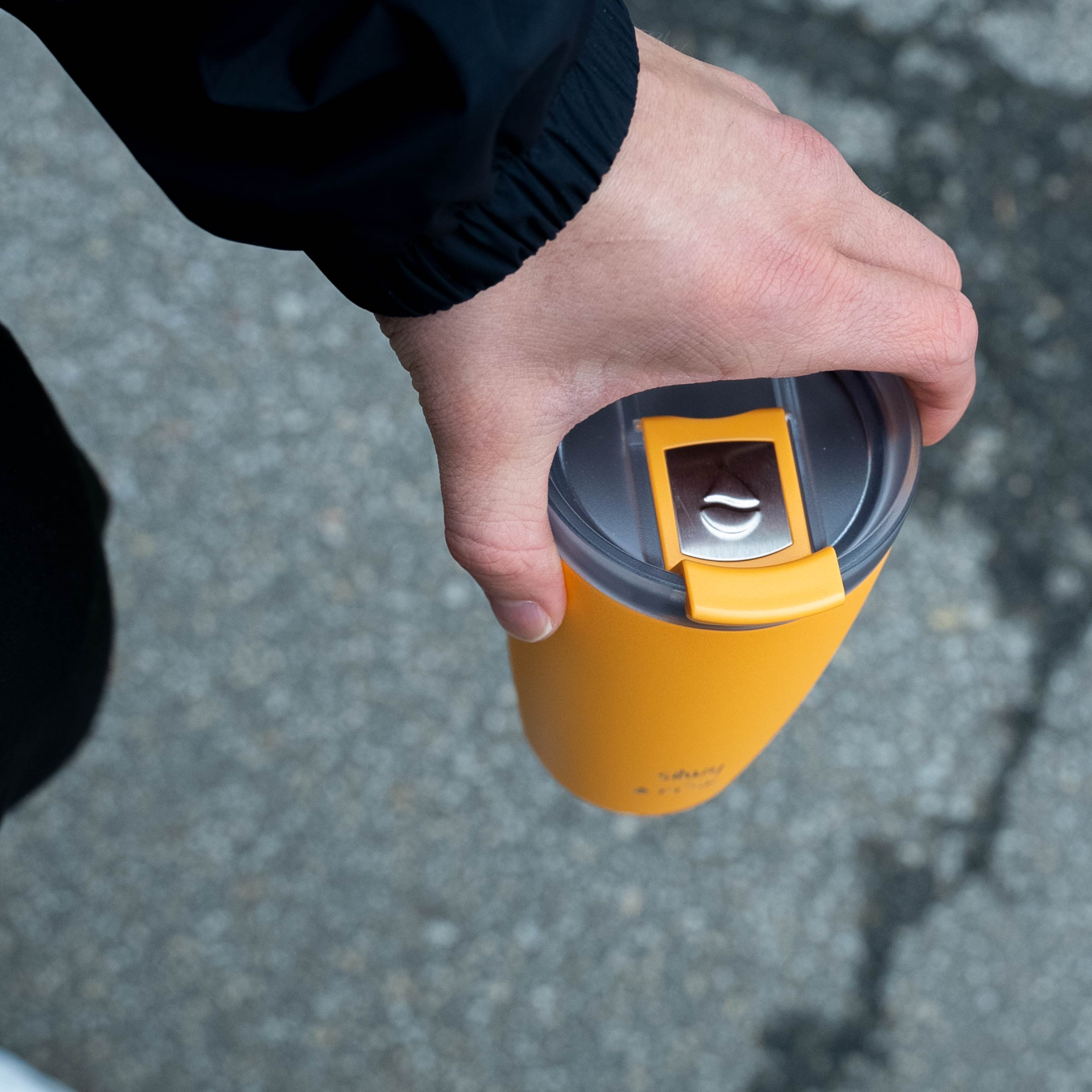 Der silwy x FLSK Thermocup in der Farbe sunrise ist geschlossen und wir in der Hand gehalten