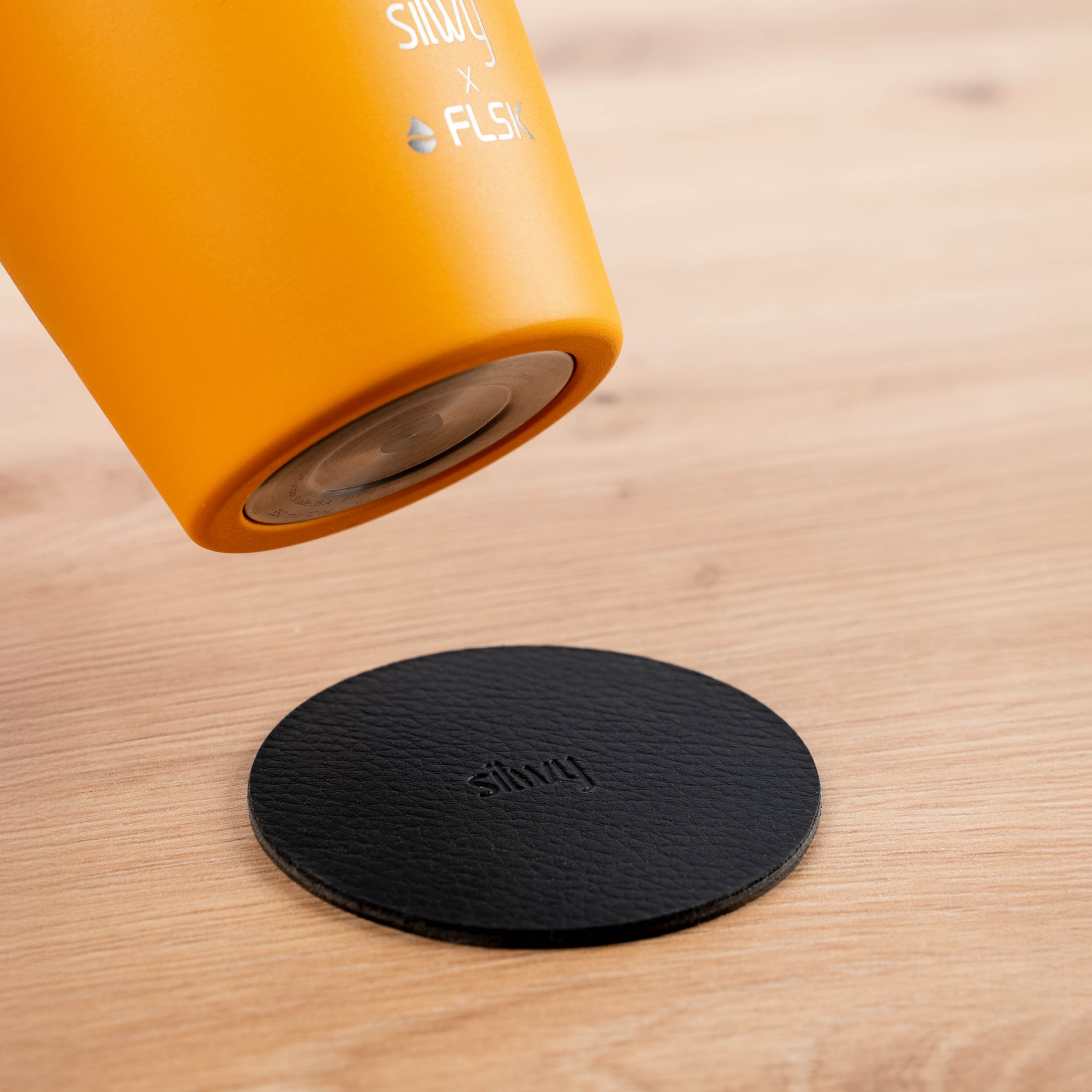 Der silwy x FLSK Thermocup in der Farbe sunrise mit einem integrierten Magneten im Boden und dem runden Metall-Nano-Gel-Pad 