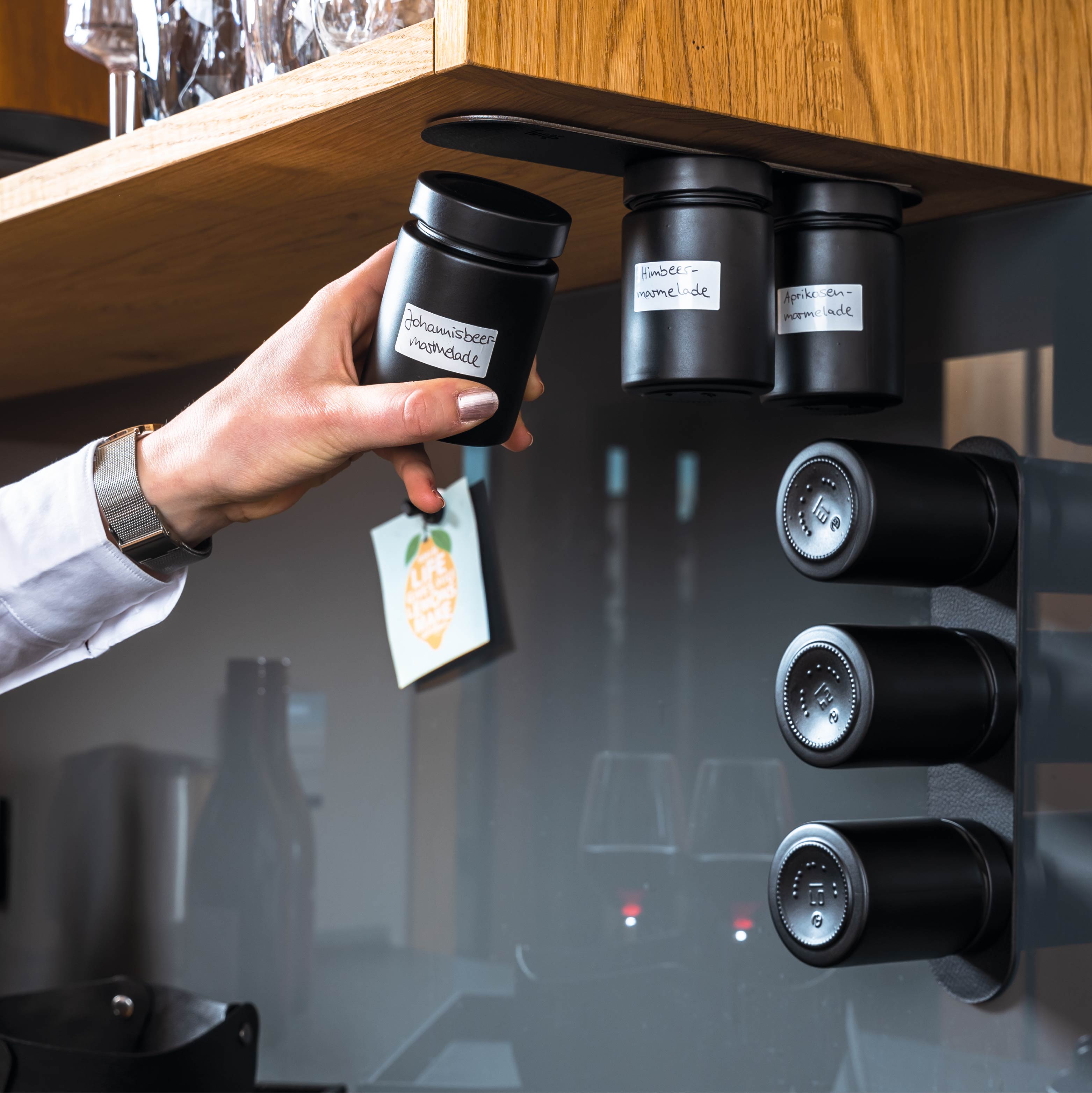 Magnet-Feinkostgläser an Metall-Leiste in Küchenumgebung montiert 