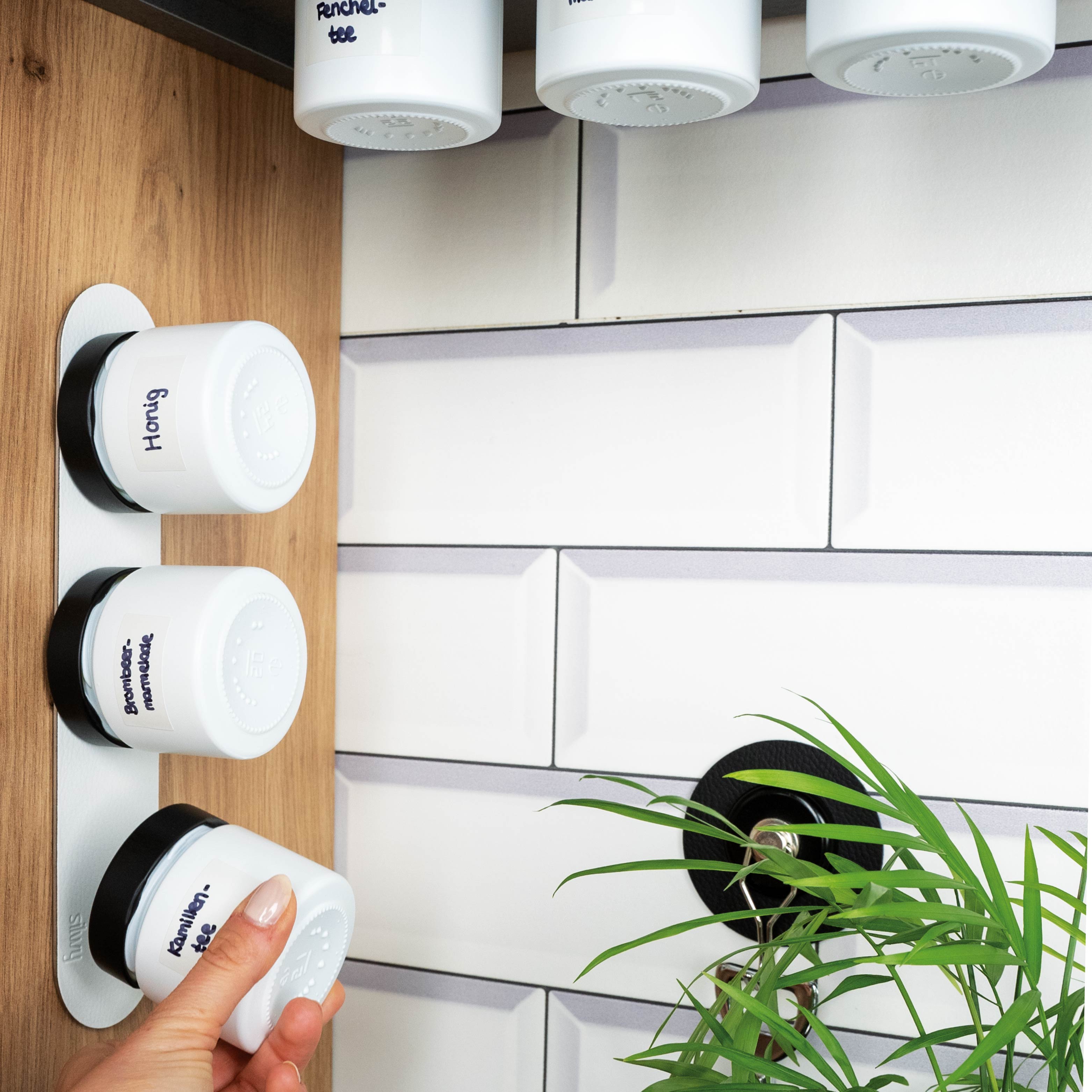 Magnet-Feinkostgläser an Metall-Leiste in Küchenumgebung montiert 