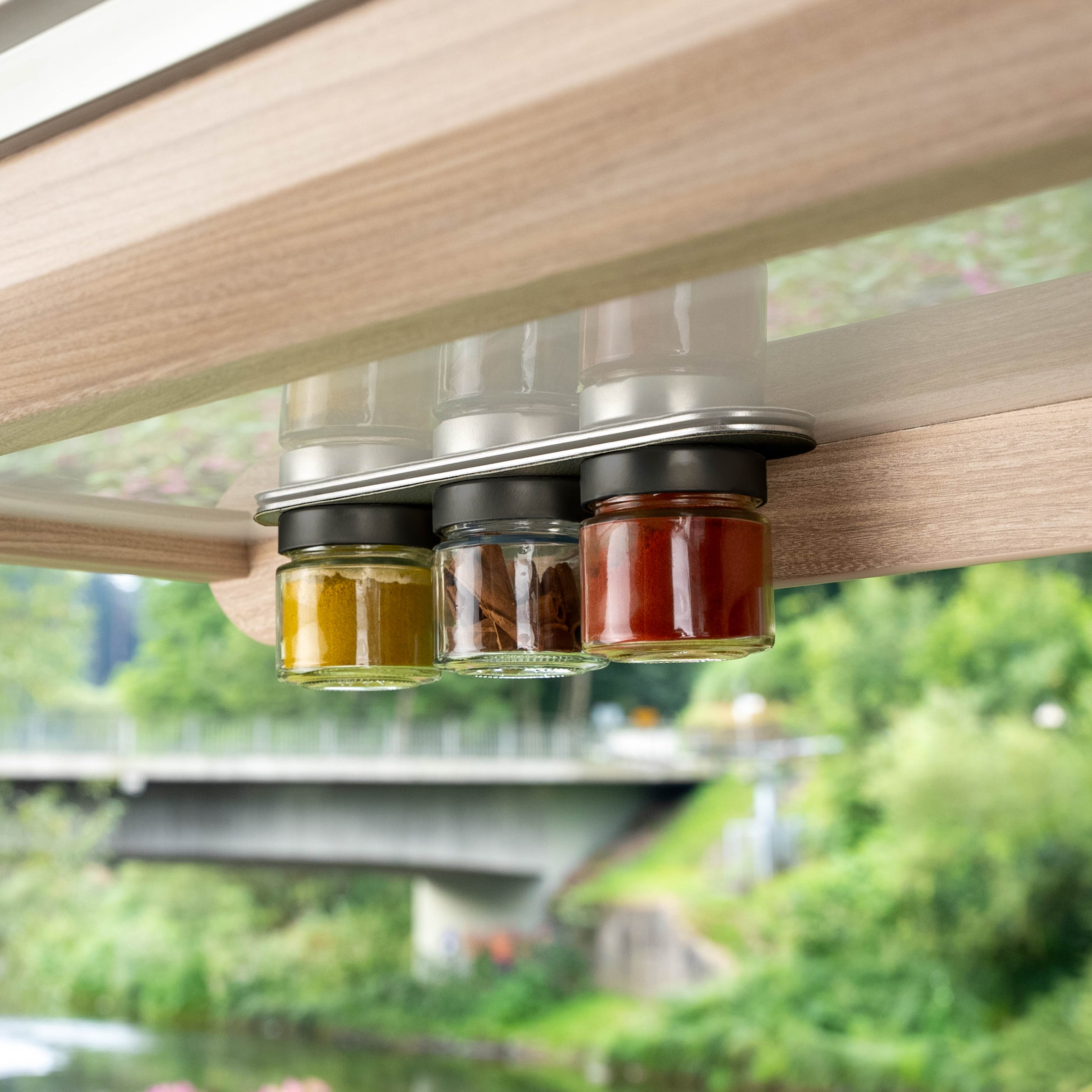 Magnetische Feinkostgläser an Leiste hängend im Camper 