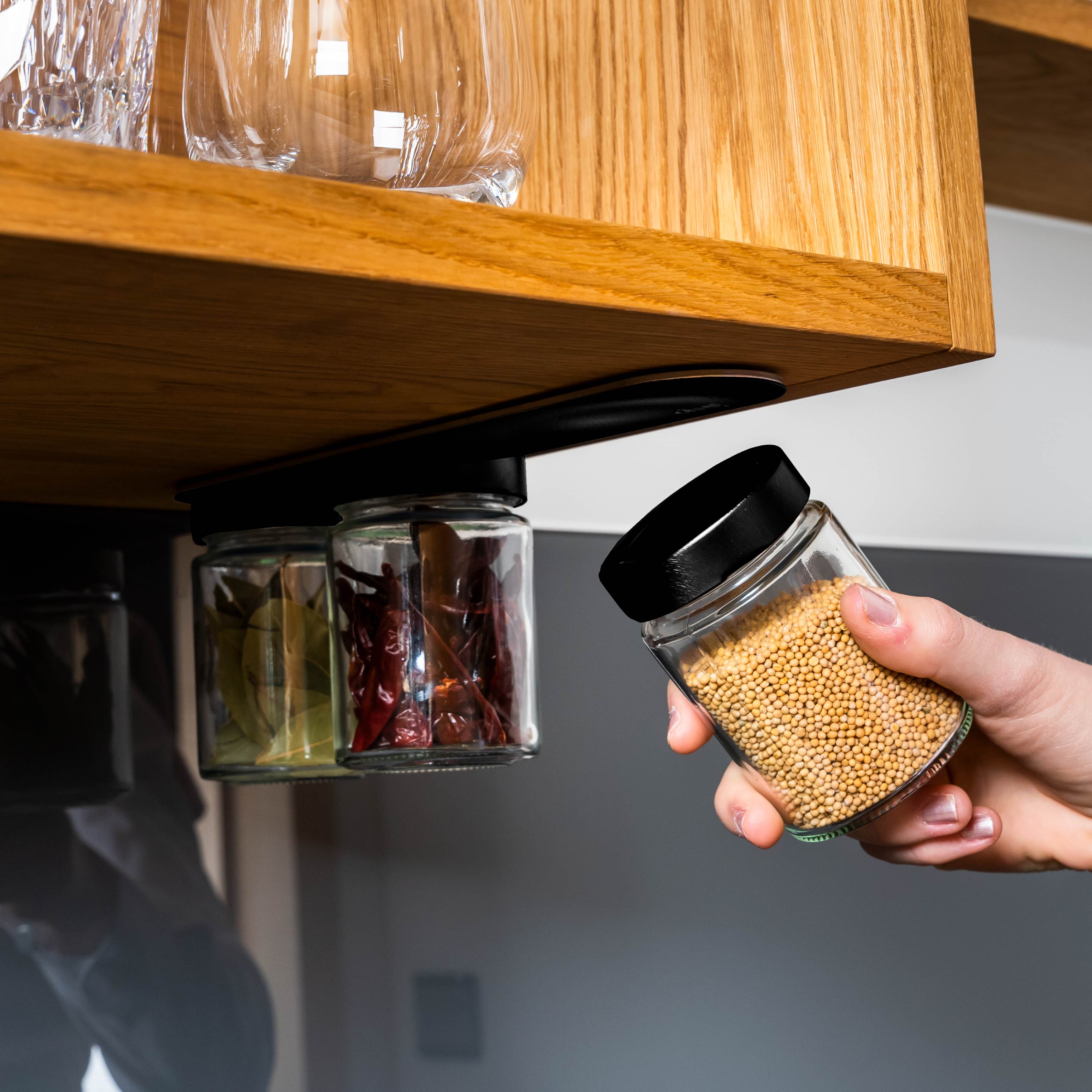 Magnet-Feinkostgläser an Metall-Leiste in Küchenumgebung montiert 