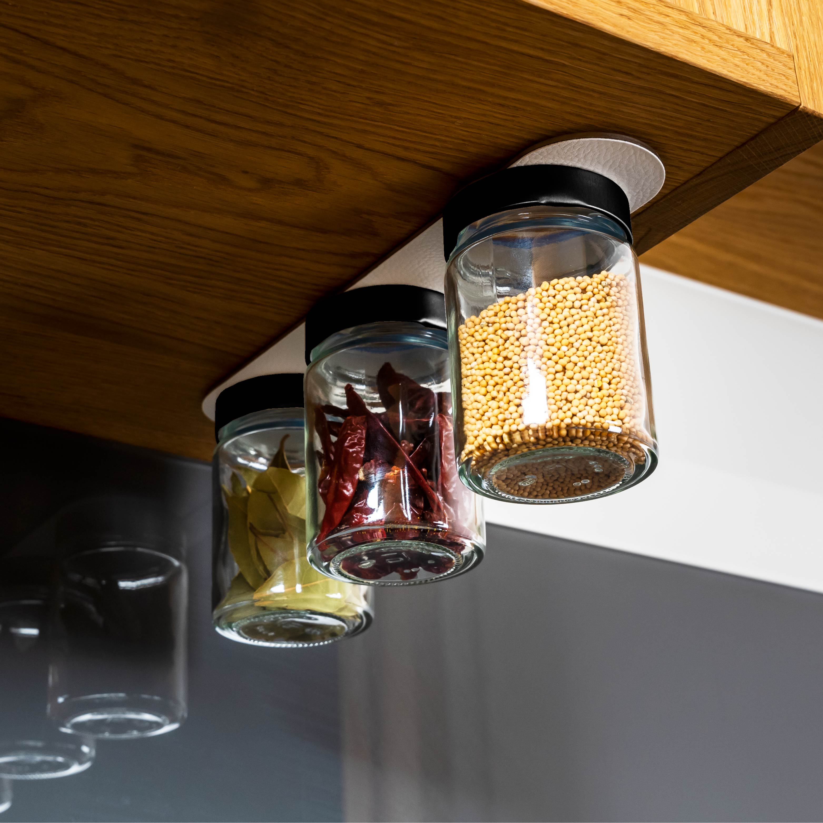 Magnet-Feinkostgläser an Metall-Leiste in Küchenumgebung montiert 